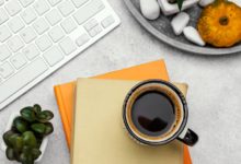 Productivity planner, coffee, and laptop on a work desk